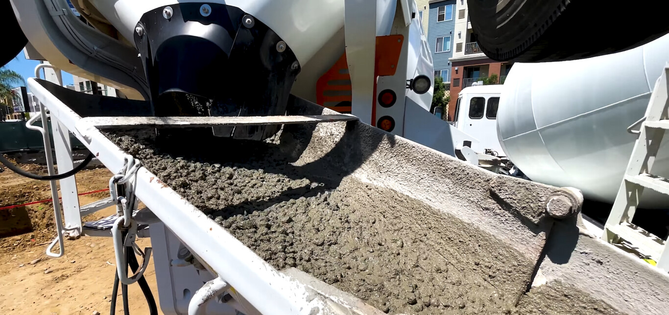 Concrete being poured from cement mixer truck at residential job site